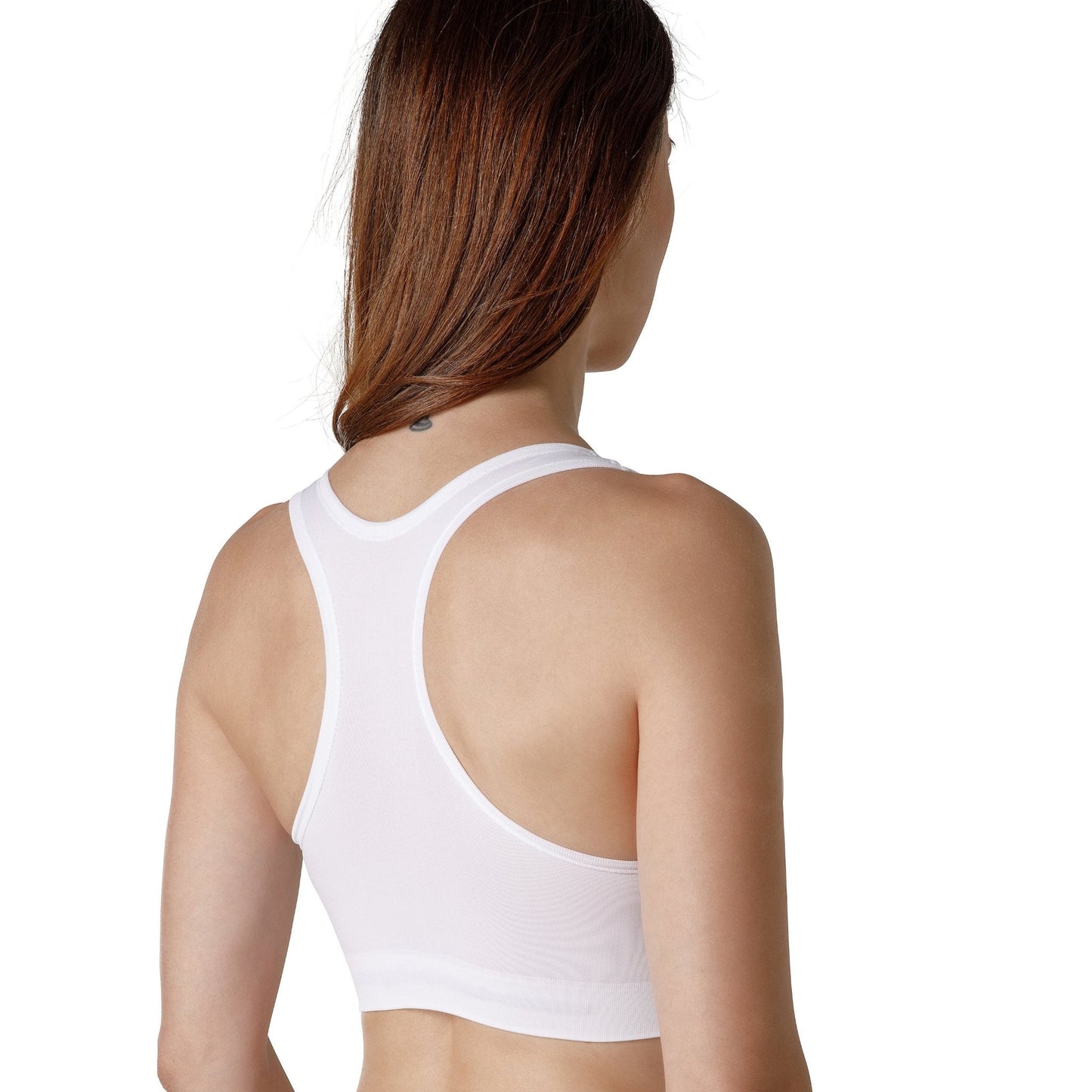 The back of a dark-haired woman wearing a white sport bra with wide straps from Tremonte.
