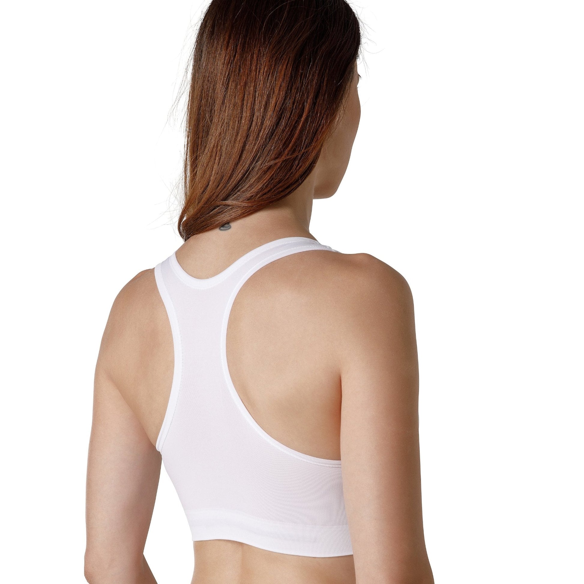 The back of a dark-haired woman wearing a white sport bra with wide straps from Tremonte.